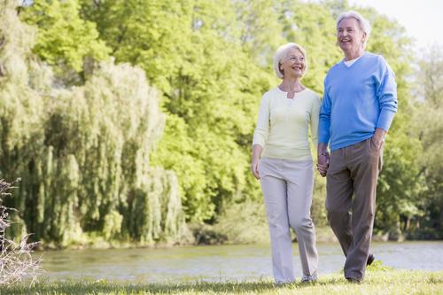 Image of an elderly couple walking in a scenic environment 