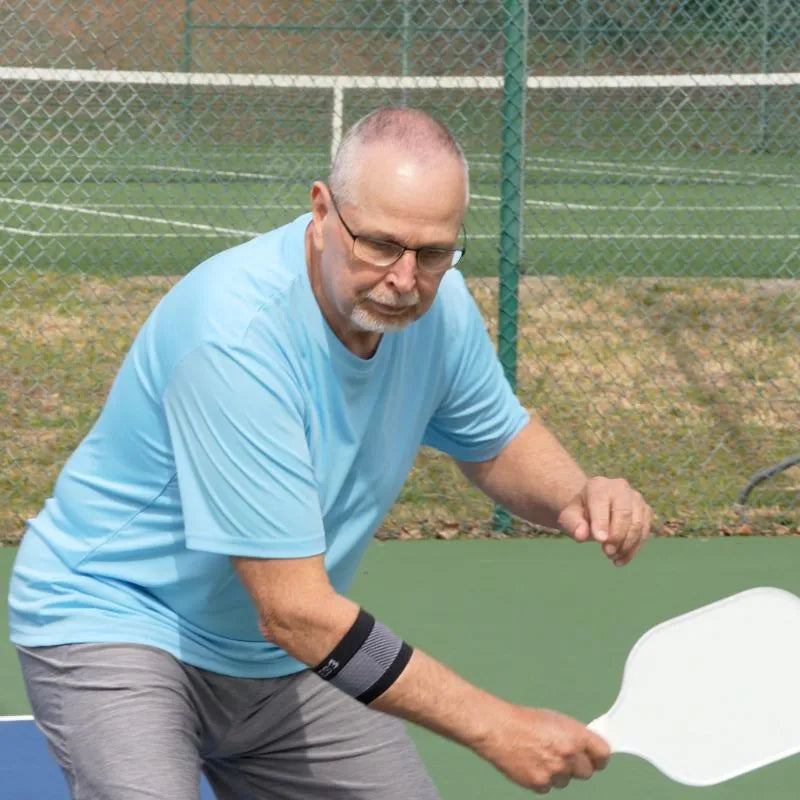Man wearing the OrthoSleeve ES3 Compression Elbow Sleeve while playing pickleball