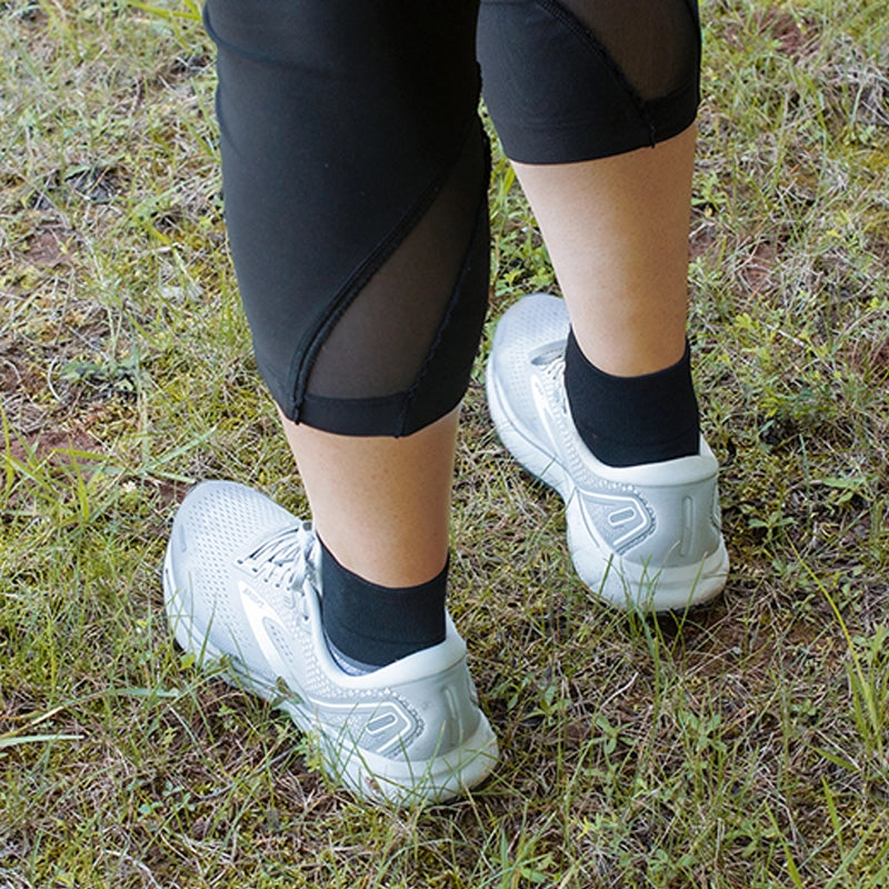 Close up of a woman's feet wearing Diabetic and Neuropathy Non-Binding Wellness Socks in Quarter Crew Black