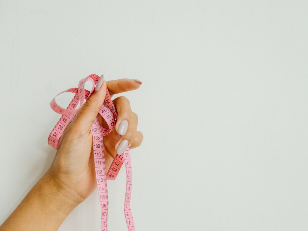 Woman holding a pink measuring tape