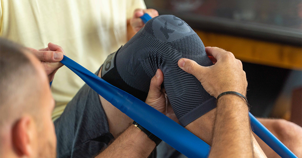 Man wearing the OrthoSleeve Stabilizing Knee Brace while attending physical therapy