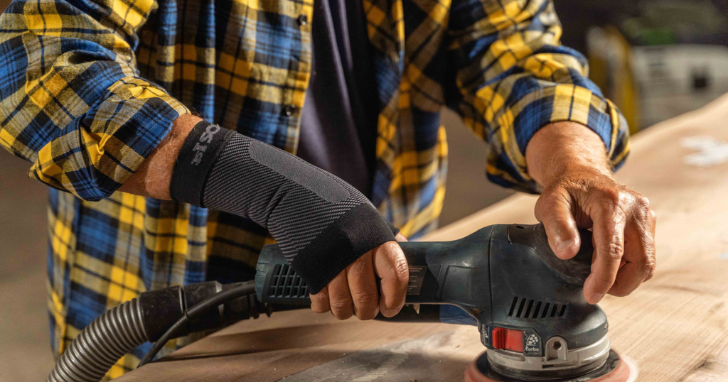 Man woodworking while wearing the OrthoSleeve Wrist Compression Sleeve