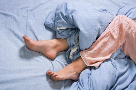 A female's legs that are laying in bed
