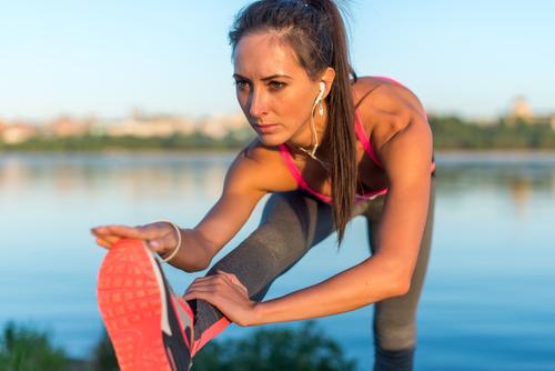 A woman stretching before her run outside