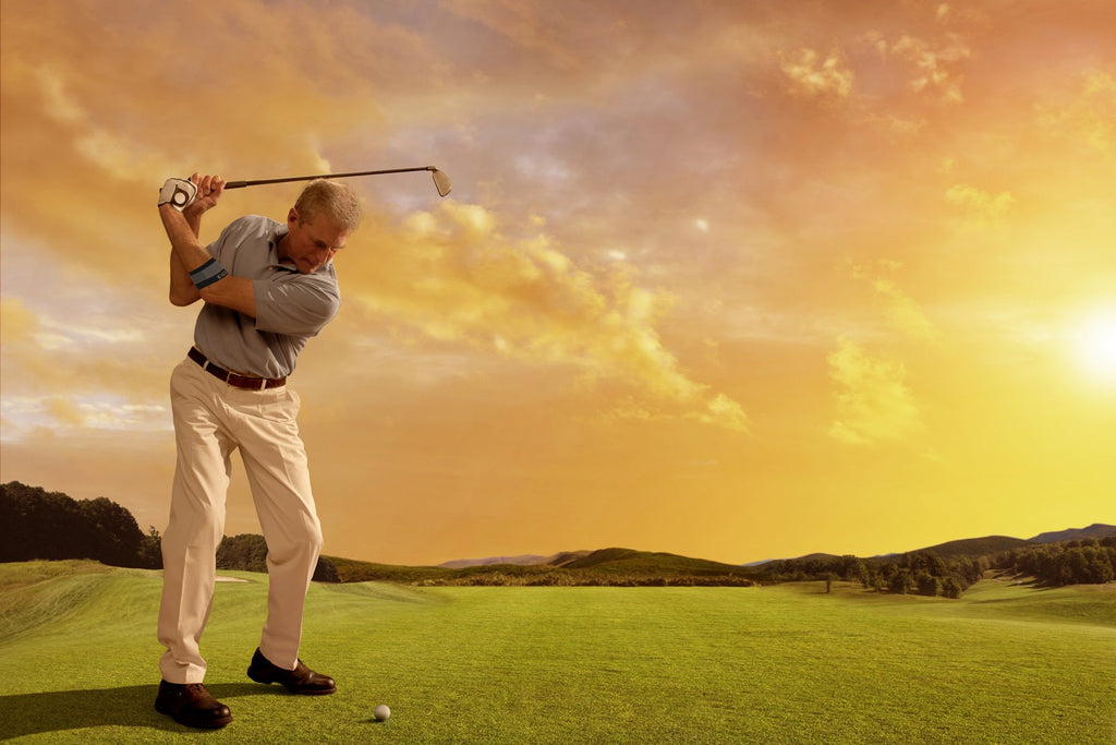 A male playing golf during sunset