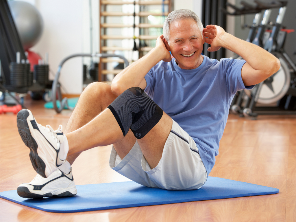 Man doing stretches while wearing the OrthoSleeve Compression Knee Brace
