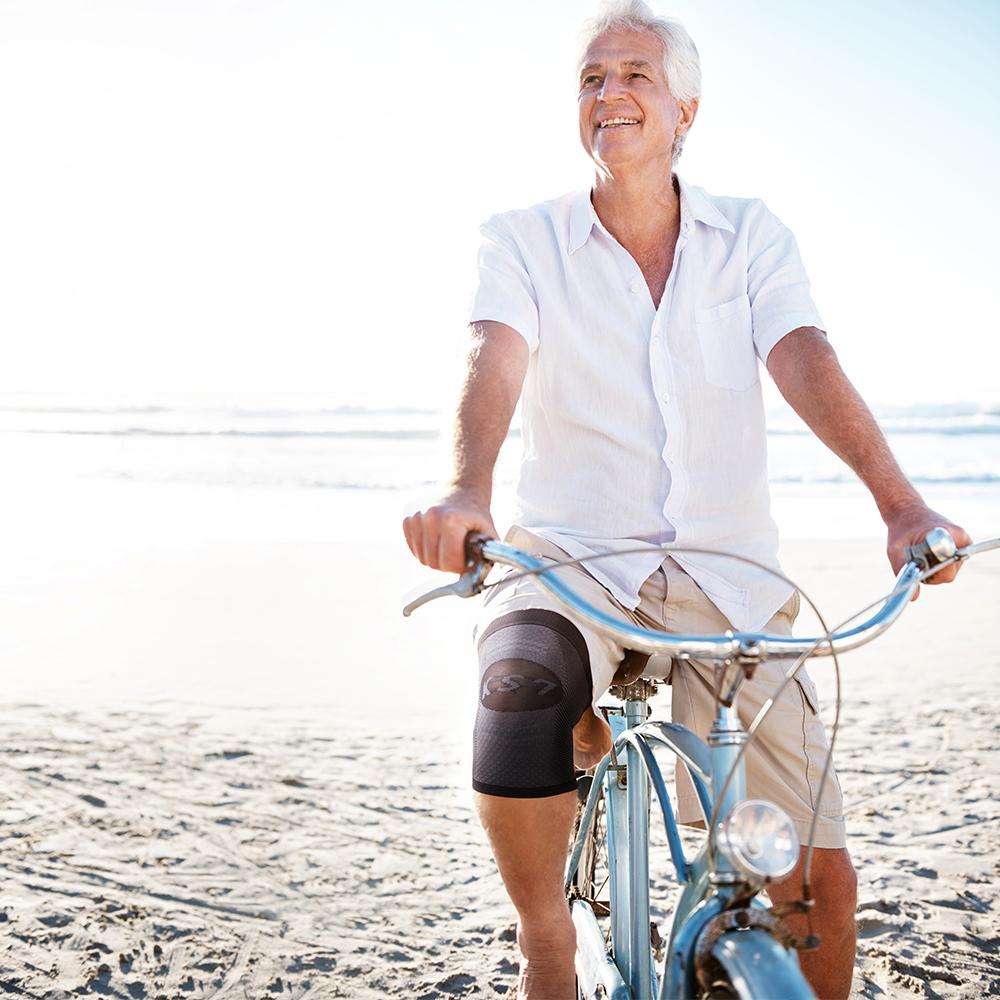 Older gentleman riding a bike along the beach