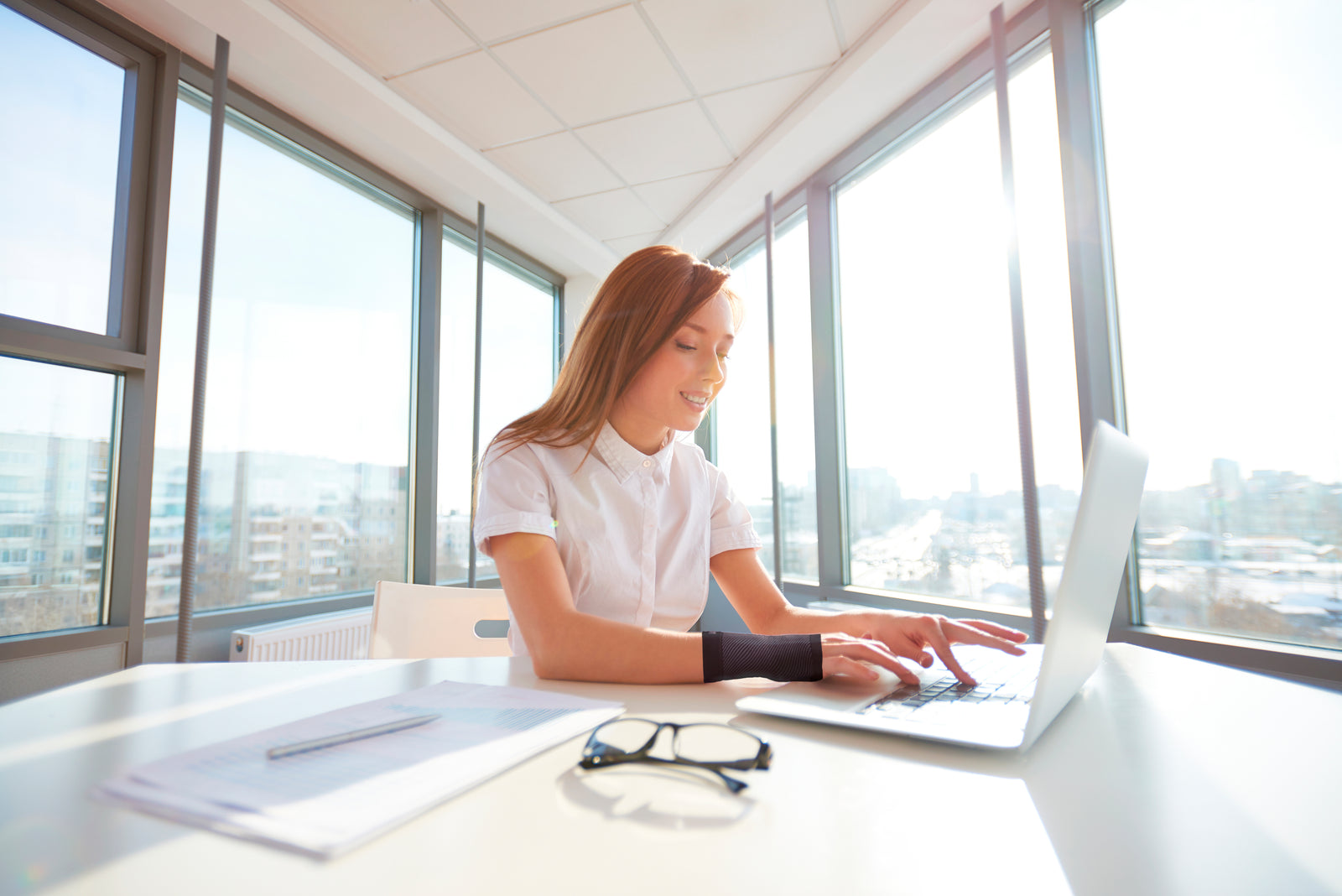 Woman sitting at a desk doing work on a laptop