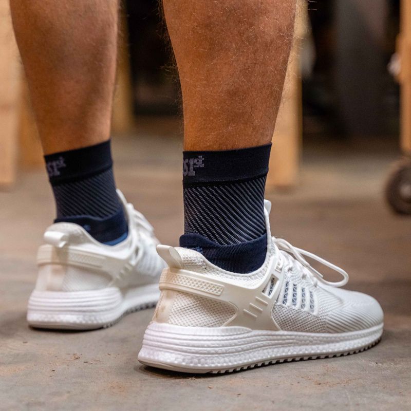 Man wearing a pair of OrthoSleeve Plantar Fasciitis Foot Sleeves while working