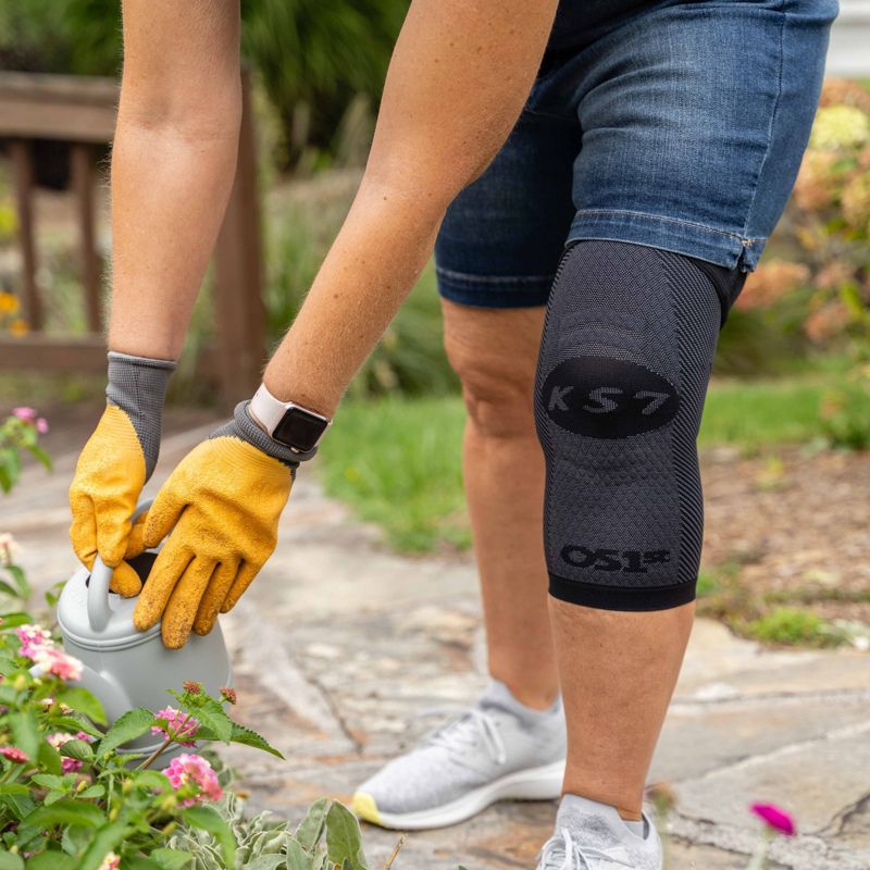 Woman wearing the OrthoSleeve Compression Knee Brace while gardening