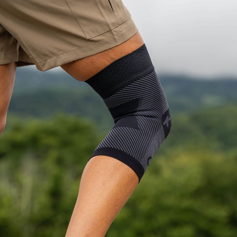 Person wearing the OrthoSleeve Compression Knee Brace while hiking in the mountains