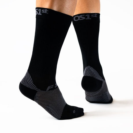 Person wearing the OrthoSleeve black crew length plantar fasciitis socks