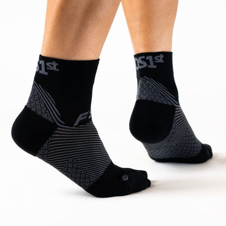 Person wearing the OrthoSleeve black quarter crew length plantar fasciitis socks