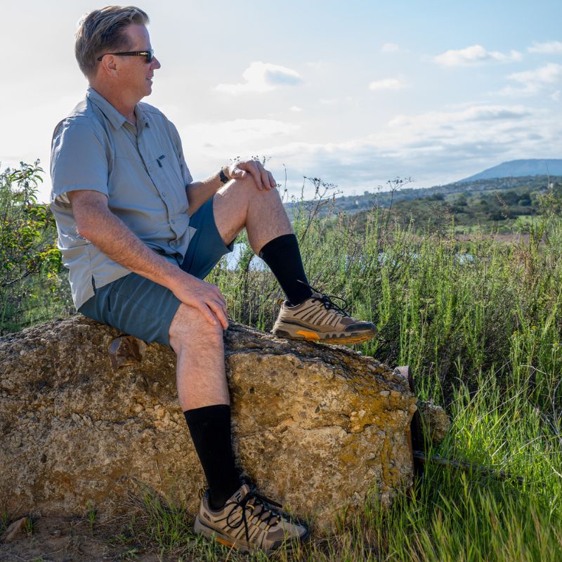 Man wearing the OrthoSleeve Plantar Fasciitis Crew Socks in black while hiking