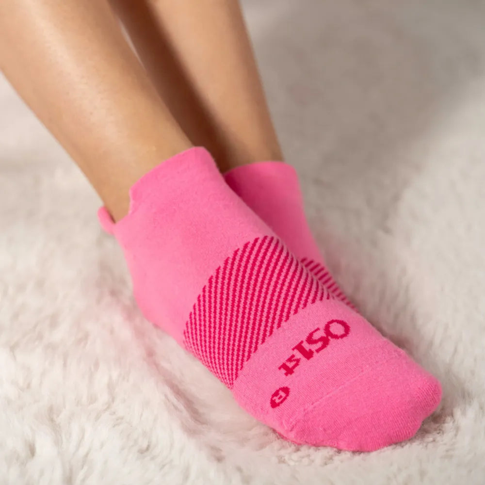 woman wearing pink wicked comfort socks contrasted against a white fuzzy rug to represent the sock's softness | OS1st