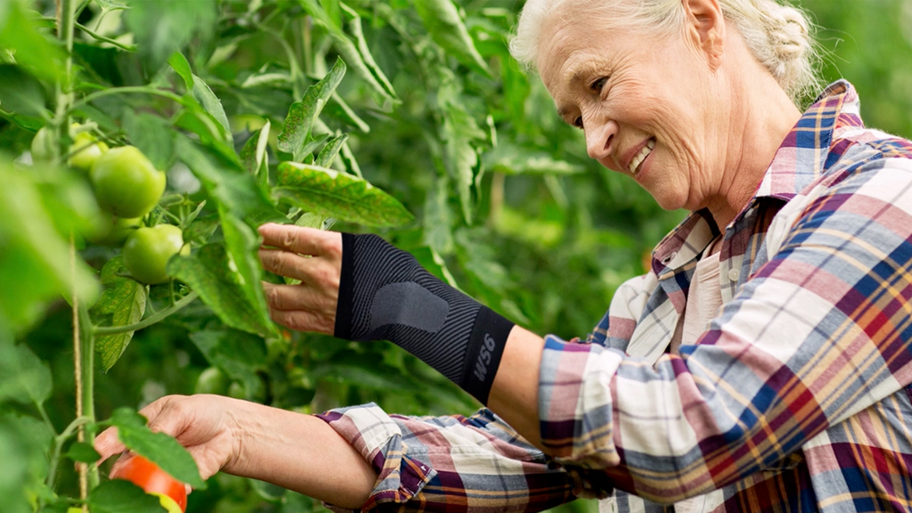 Woman in a tomato garden wearing the wrist compression sleeve