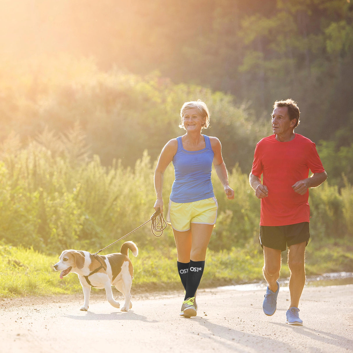 A woman wearing compression bracing socks while holding a dog on a leash 