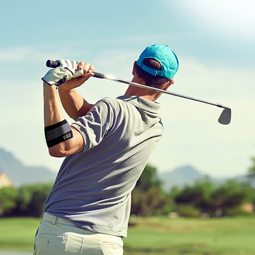 Man golfing while wearing the compression elbow brace