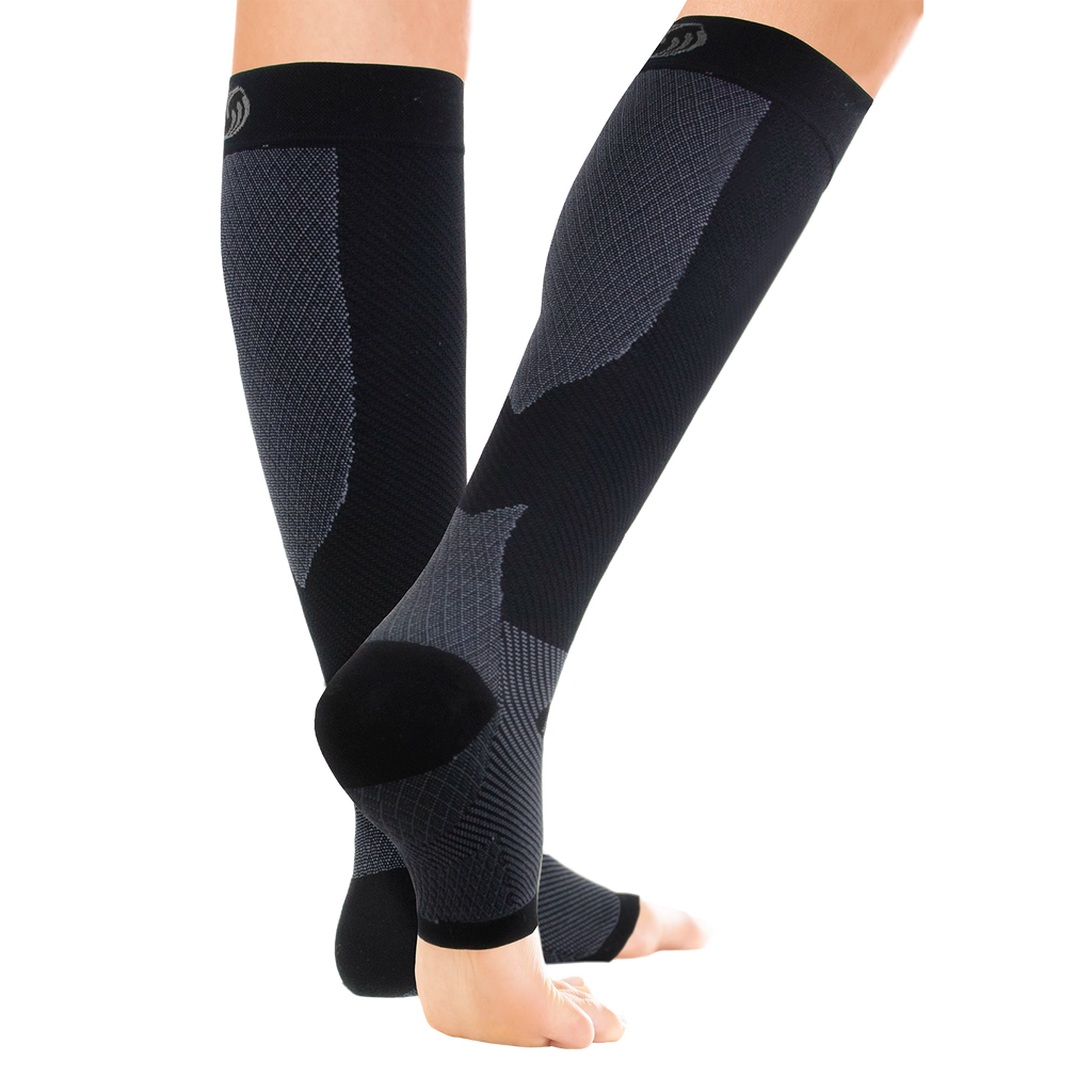 Pair of legs wearing the black compression leg sleeves