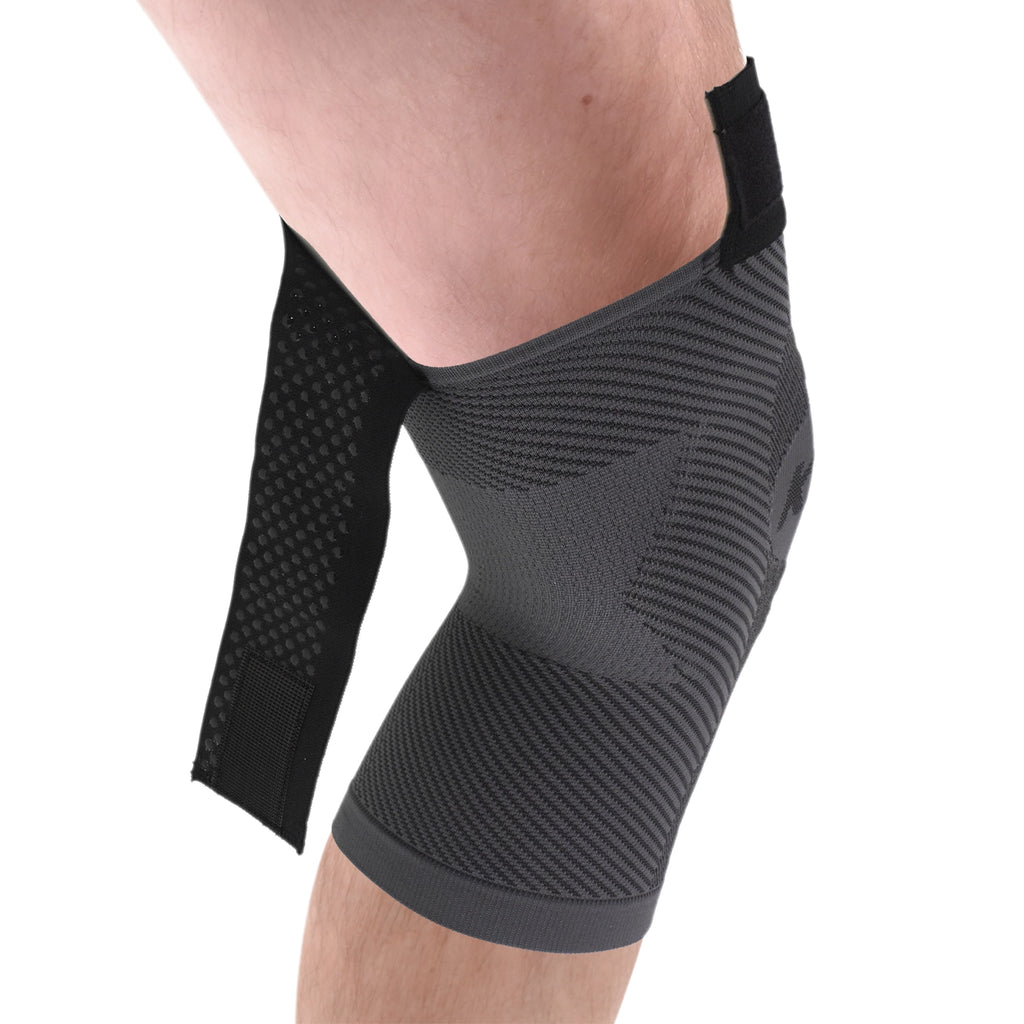 A man's leg with the knee sleeve on and the adjustable strap left open