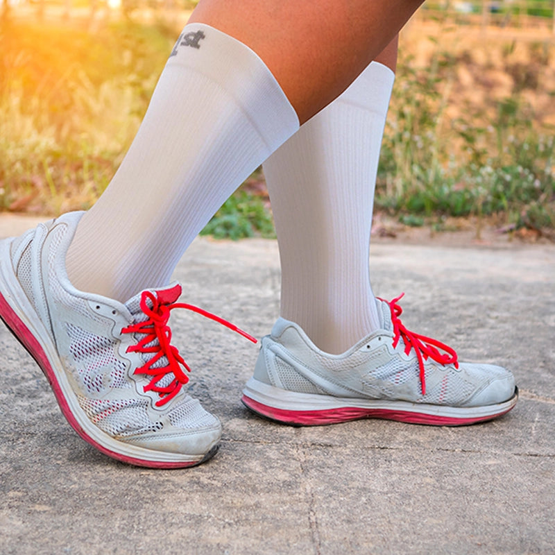 Woman wearing the white, crew wide size socks in her wide shoes while on a walk outside